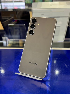 Samsung smartphone on a stand with a blurred indoor background