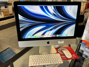 Apple iMac computer on display in a store with keyboard and mouse.