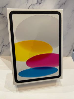 A white rectangular tablet box or packaging standing upright on a white surface, with a black-bordered screen graphic showing overlapping yellow, pink, and blue shapes against a marble-patterned background.