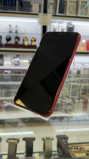 Red iPhone on a reflective surface with blurred background