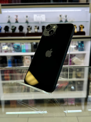 Black smartphone on a stand with a blurred store shelf in the background