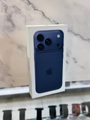 A boxed Apple iPhone with a dark blue back panel and white retail box, standing upright against a light marble-patterned background.