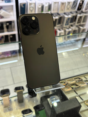 Black Apple smartphone on display in a store with various electronic devices in the background.