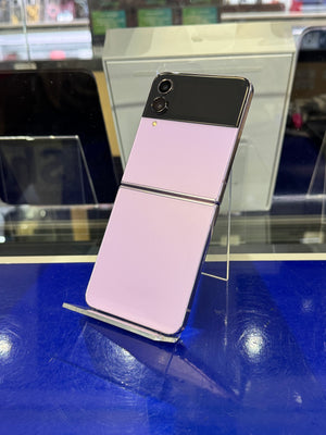 Foldable smartphone on display stand with a blurred store interior background