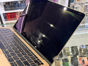 Gold laptop with a reflective screen in a store setting