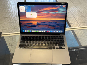 Laptop on a glass surface with a scenic wallpaper
