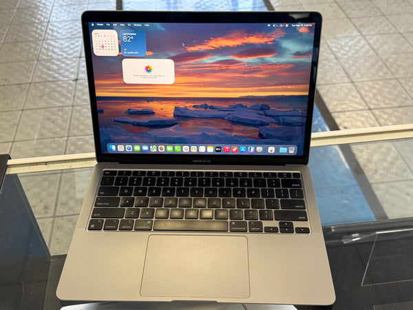 Laptop on a glass surface with a scenic wallpaper