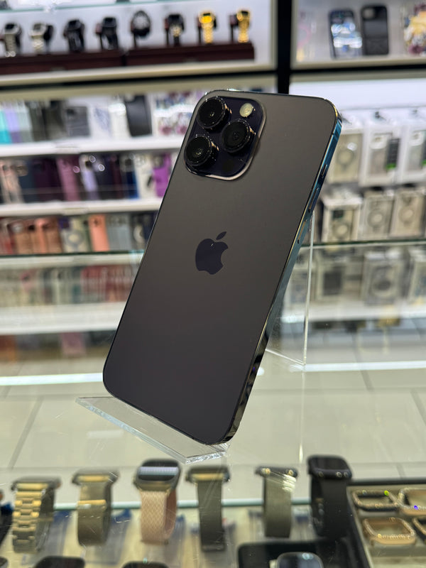 Black smartphone with Apple logo on a reflective surface with blurred store interior background