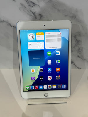 A white Apple iPad tablet standing upright on a clear acrylic display stand against a white marble-patterned background.