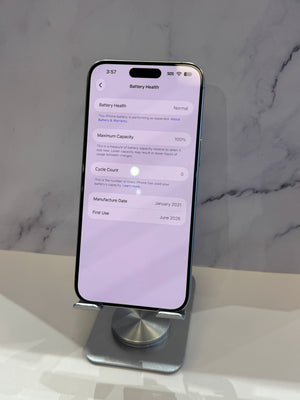 A smartphone displayed upright on a metal stand against a light marble-patterned background, with the screen showing battery health settings.