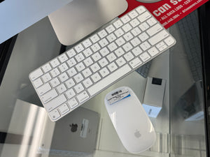 Apple keyboard and mouse on a glass surface with a blurred background