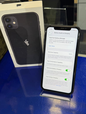 Smartphone with screen on displaying settings menu, placed on a blue surface with an Apple box in the foreground.