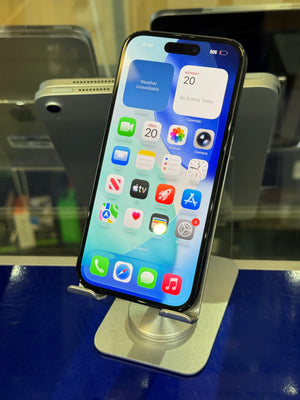 A black smartphone with its screen turned on, resting on a metallic display stand in front of a blue glass display case.