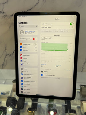 An iPad displaying the Settings app, with the Battery section visible on screen, photographed against a marble-patterned background.