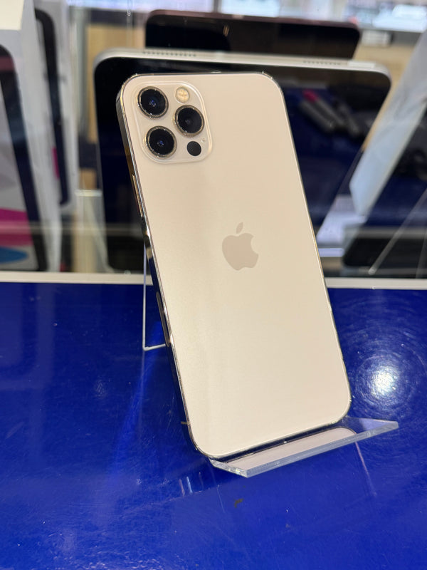 A gold Apple iPhone shown from the back, resting on a clear display stand against a bright blue surface.