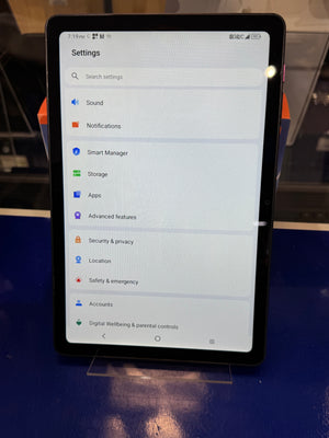 Tablet displaying settings menu on a reflective surface