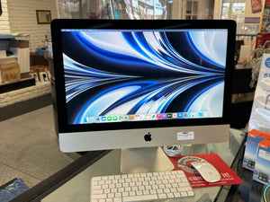 Computer monitor with keyboard and mouse on a glass desk in a store setting