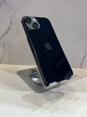A black Apple iPhone 13 Pro displayed on a silver metal stand, showing the back of the phone with its dual camera system and the Apple logo.