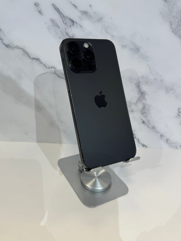 A black Apple iPhone Pro showing the back of the device, resting on a silver metal stand against a white and gray marble-patterned background.