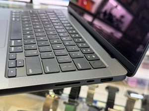Close-up of a laptop keyboard and ports on a reflective surface