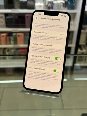 Smartphone displaying battery health screen on a reflective surface
