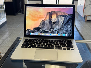 Laptop on a glass surface with a mountainous landscape on the screen
