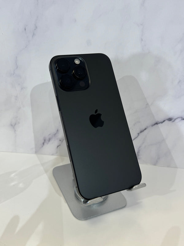 A black Apple iPhone 12 Pro shown from the back, resting on a silver metal stand against a white marble-patterned background.