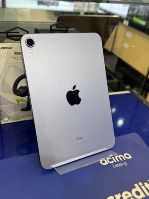 Silver iPad with Apple logo on a blue surface 