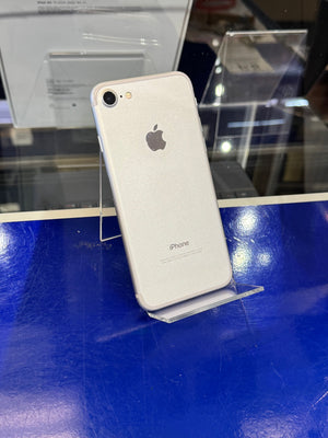 White iPhone on a stand with blue surface and reflective background