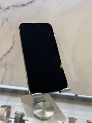 A silver smartphone with a black screen resting on a metallic magnetic stand over a white marble surface.