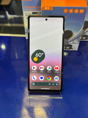 Smartphone with app icons displayed on a blue surface with a box in the background