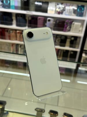 White smartphone on a stand with blurred shelves in the background