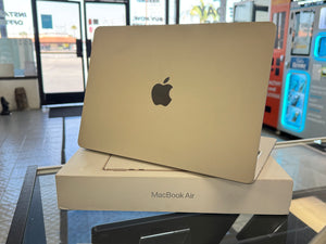 MacBook Air laptop on a glass table with a blurred store interior background