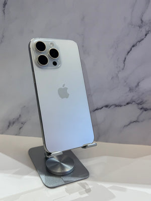A silver Apple iPhone Pro shown from the back, resting on a metallic stand against a white marble-patterned background.