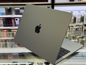 Silver laptop with Apple logo on a glass surface