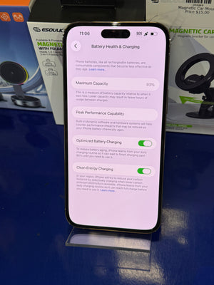 Smartphone displaying a battery health and charging app on a reflective surface with a blurred background.