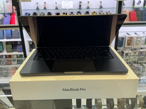 Black MacBook Pro on a beige stand with a store display in the background