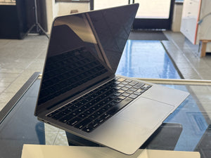 Open laptop on a glass table with a blurred indoor background