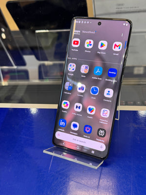 Smartphone with app icons displayed on a blue surface