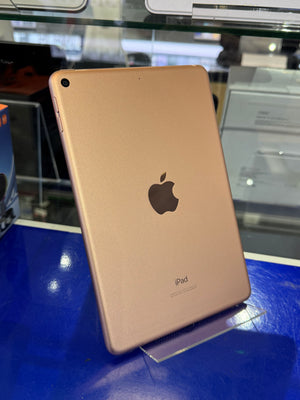 Gold iPad on a blue surface with a blurred background