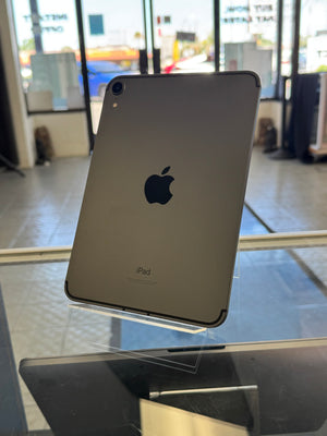 Back view of an Apple iPad on a reflective surface with blurred background