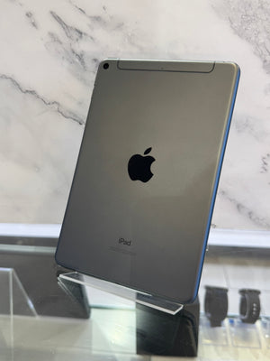 An Apple iPad shown from the back, standing on a clear display stand against a white marble-patterned background.