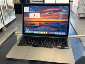 Laptop on a glass table with a scenic wallpaper