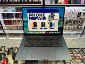Laptop displaying a phone repair website on a counter with electronic parts in the background