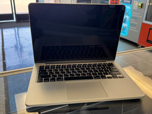 Laptop on a glass surface with a blurred indoor background