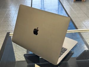 Silver laptop with Apple logo on a reflective surface