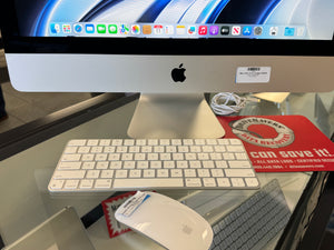 Apple iMac computer with keyboard and mouse on a glass desk