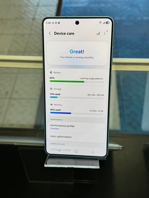 Smartphone displaying device care app on a stand with a blurred background