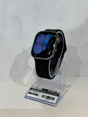 Black Apple watch on display showing a screen with numbers.  Watch is on an acrylic display against a marbled background. 