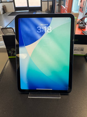 A black tablet with a colorful blue and green lock screen wallpaper, displayed on a clear stand on a dark surface.